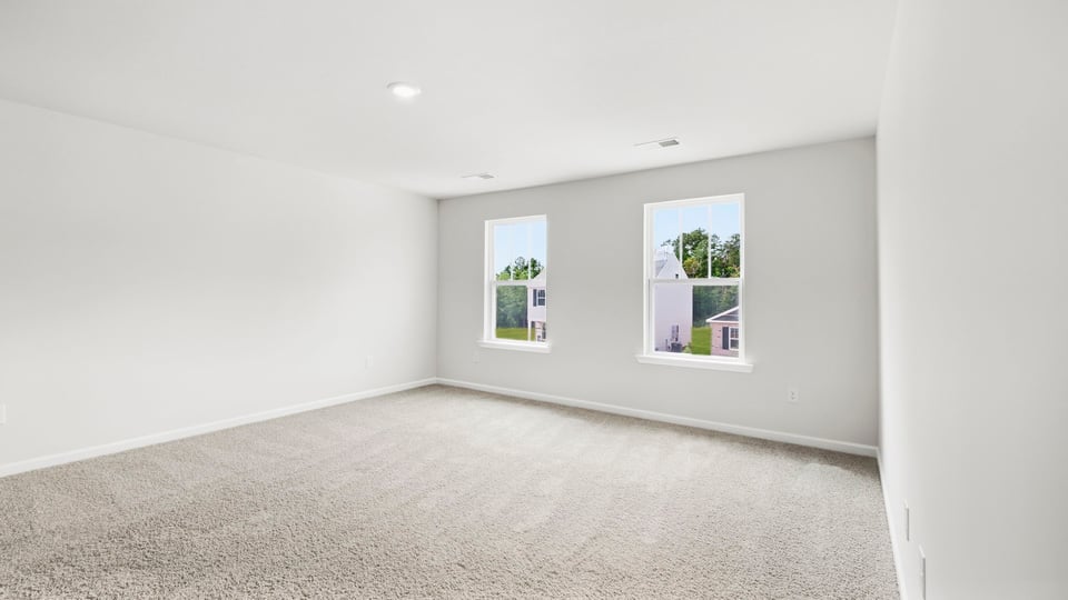 Bedroom with carpet and windows.