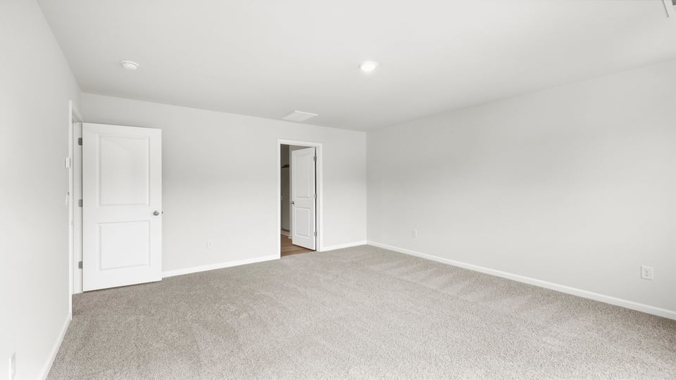 Bedroom with carpet and windows.