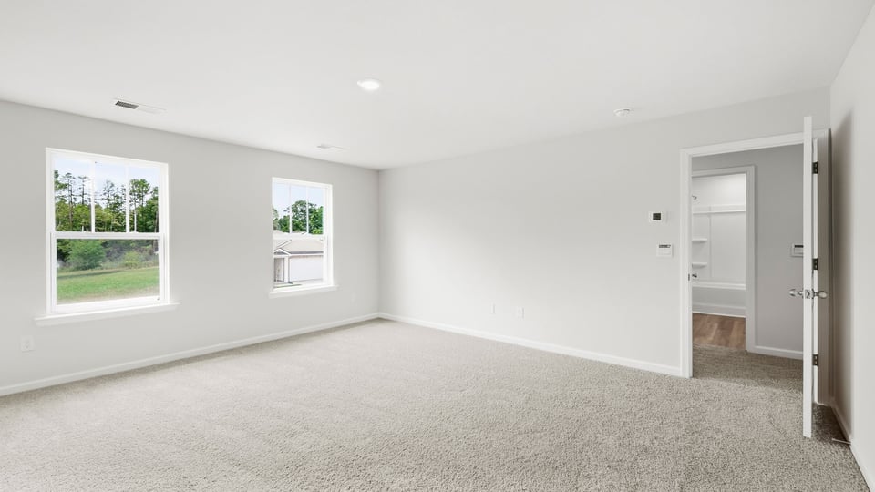 Bedroom with carpet and windows.