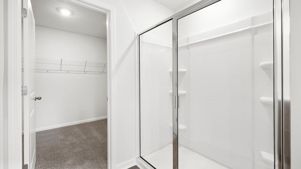 Bathroom with walk in shower and closet.