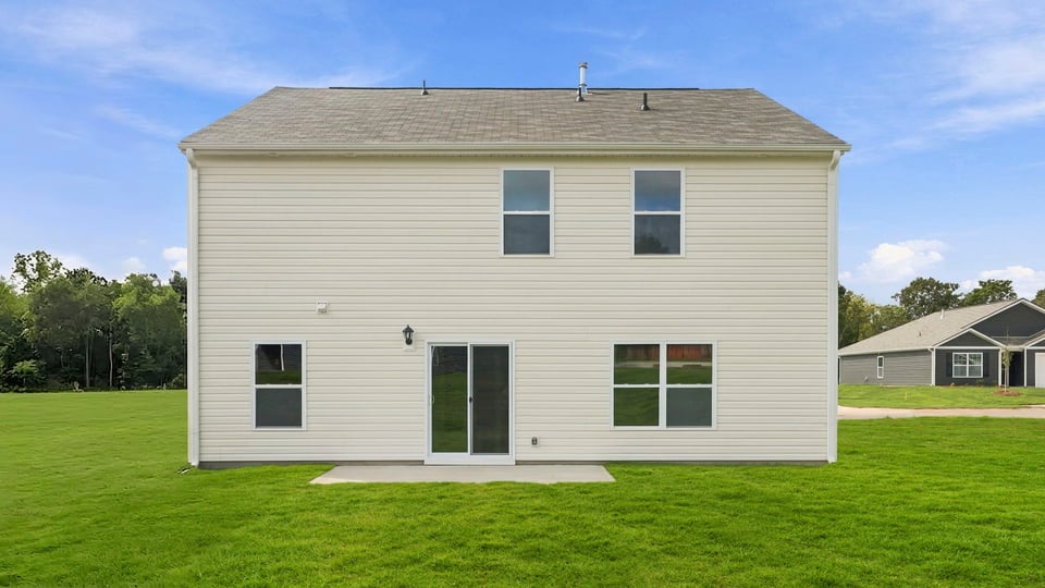 Back exterior of home with large backyard.