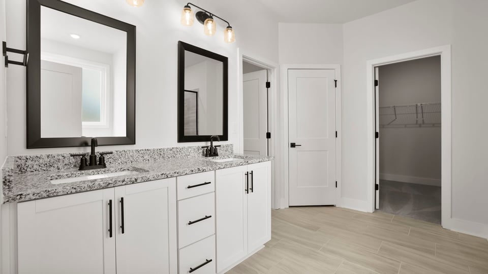Bathroom with double vanity sink and walk in closet.