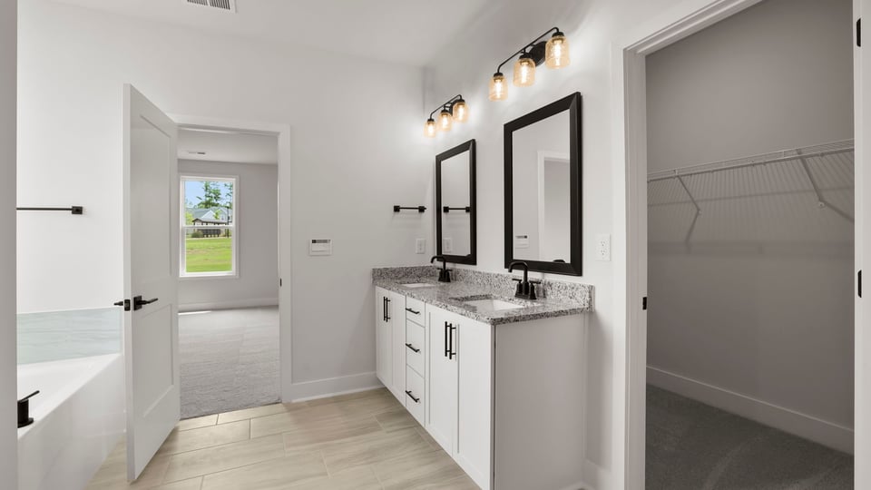 Bathroom with double vanity sink and walk in closet.