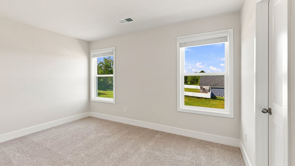 Bedroom with carpet and windows.