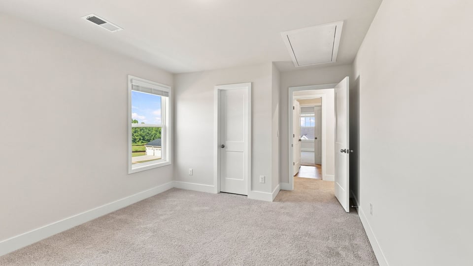 Bedroom with carpet and windows.