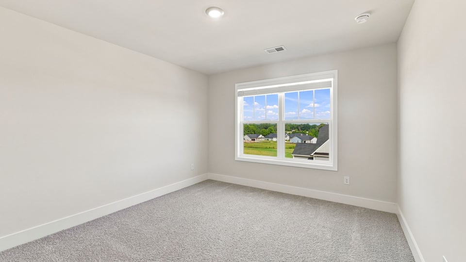 Bedroom with carpet and window.