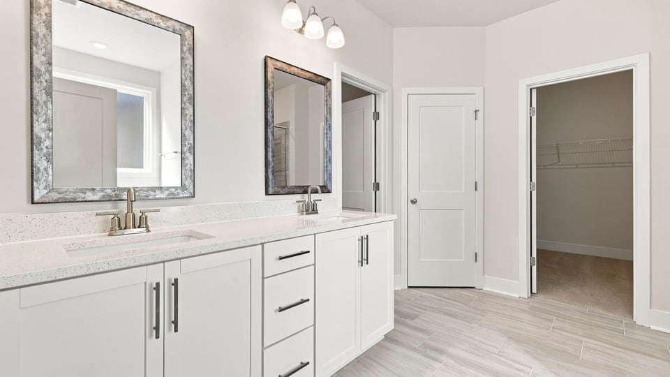 Bathroom with double vanity sink and walk in closet.