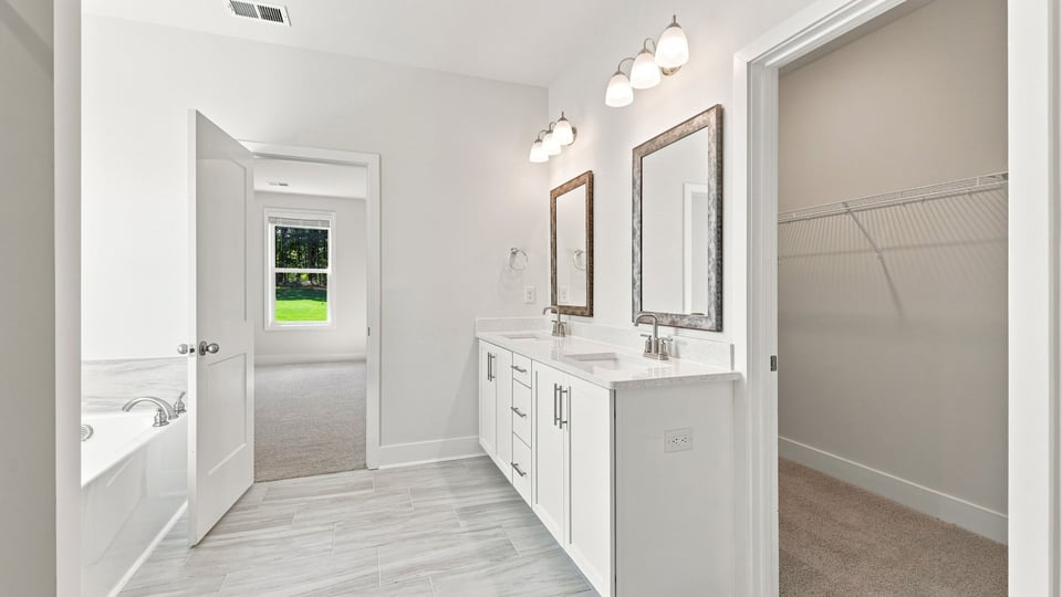 Bathroom with double vanity sink and walk in closet.