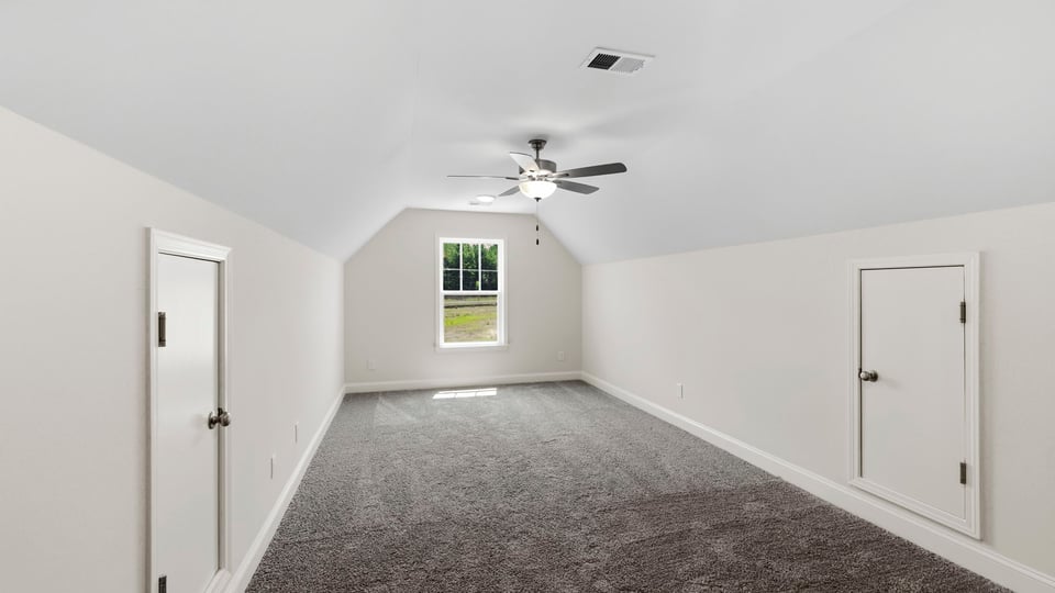 Bonus room with carpet and window.