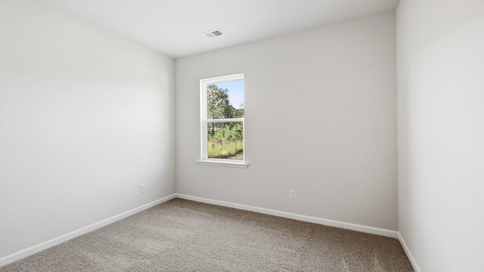 Bedroom with carpet and window.
