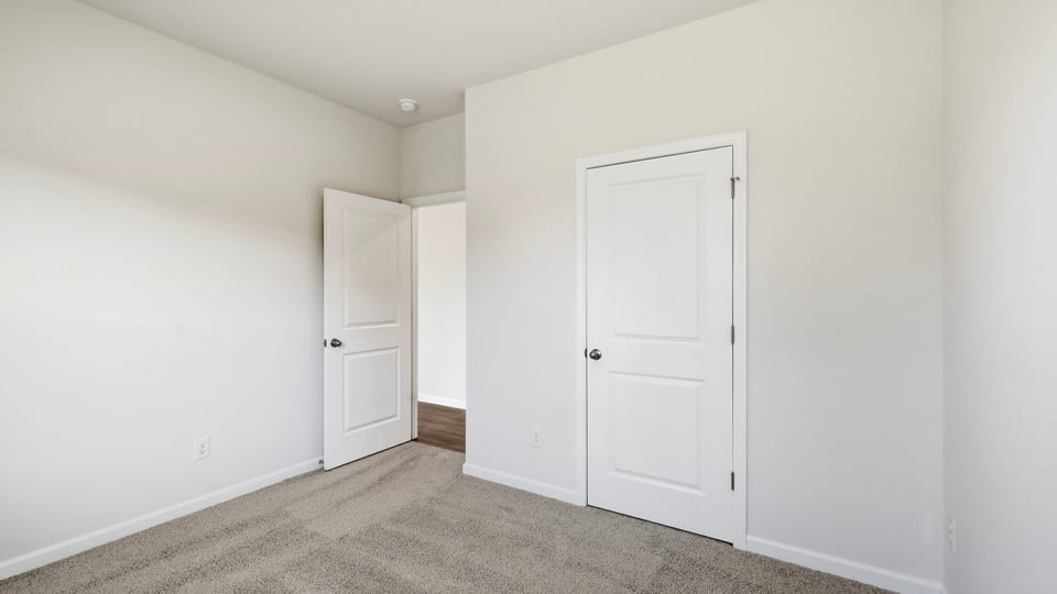 Bedroom with carpet and window.