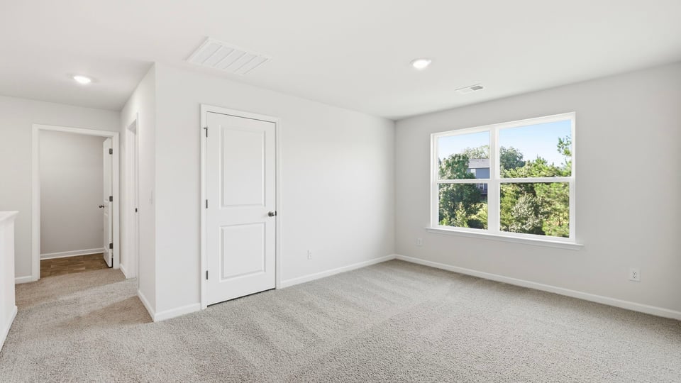 Bedroom with carpet and window.