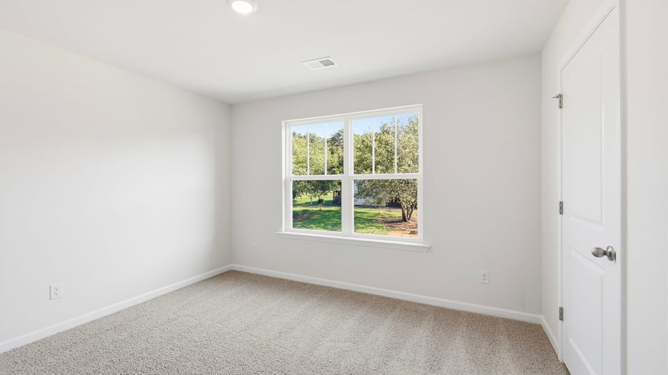 Bedroom with carpet and window.