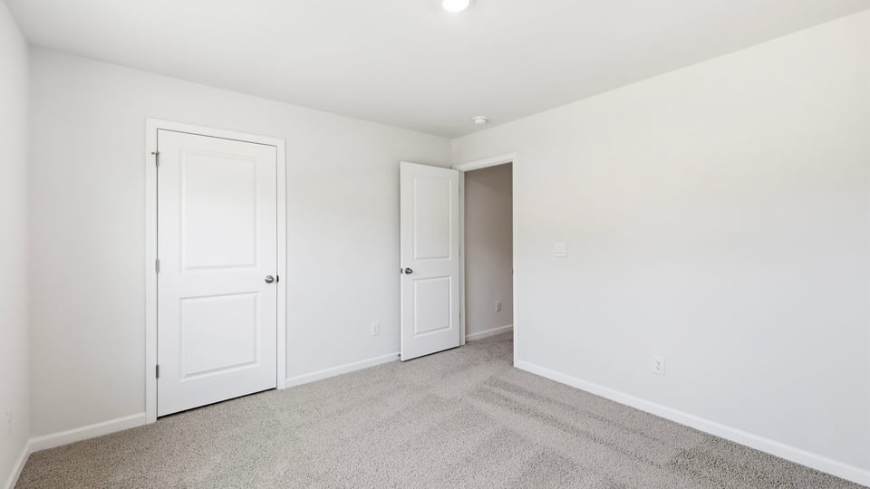 Bedroom with carpet and window.