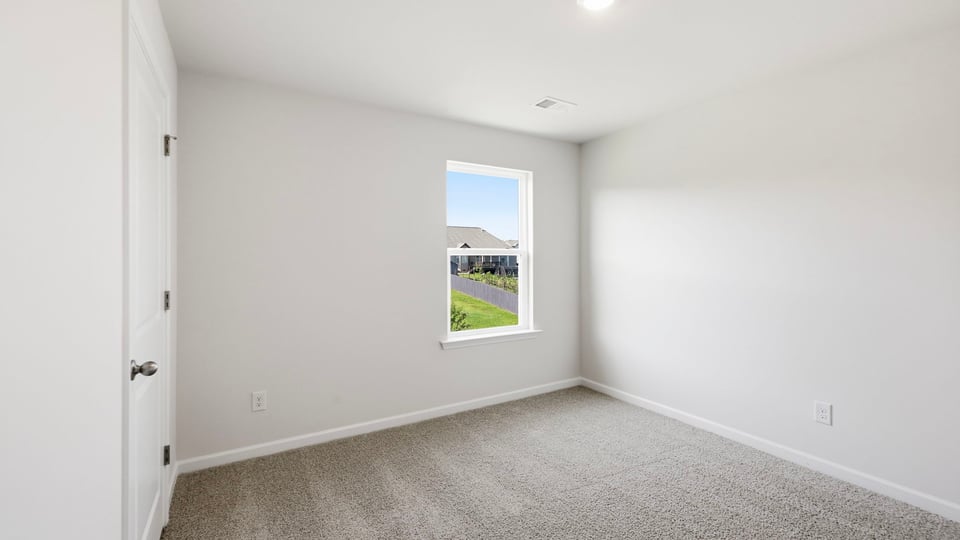 Bedroom with carpet and window.