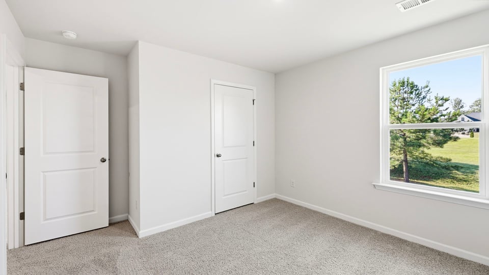 Bedroom with carpet and window.