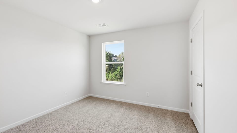 Bedroom with carpet and window.