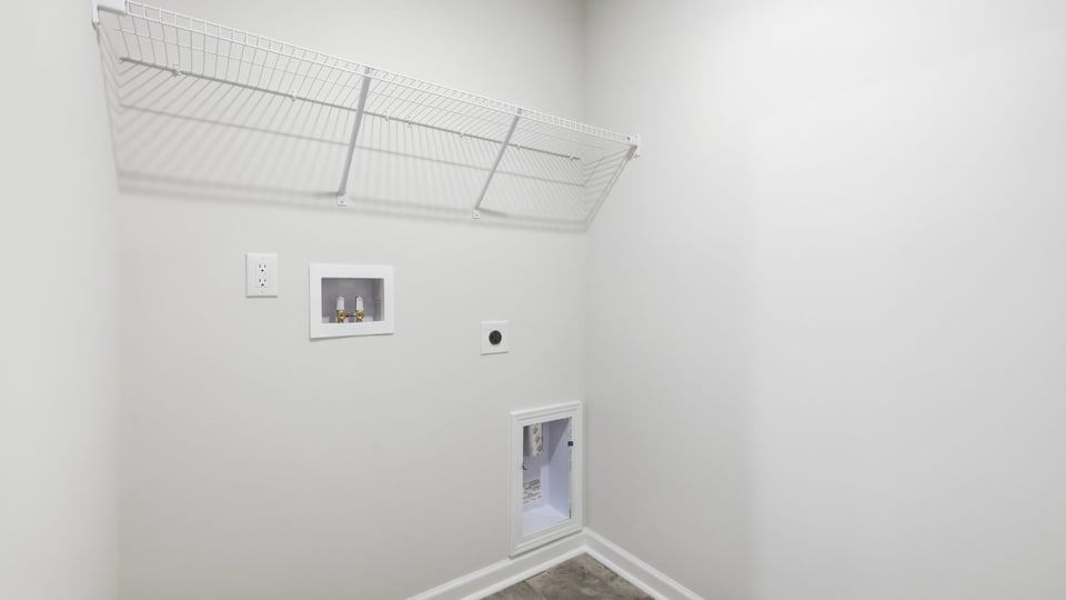 Laundry room with hanging storage racks.