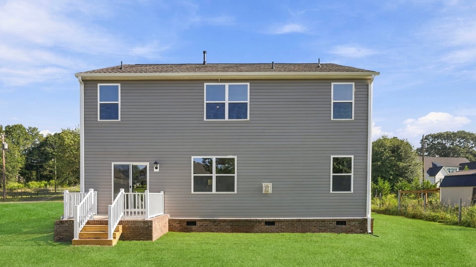 Back exterior of home with large backyard.