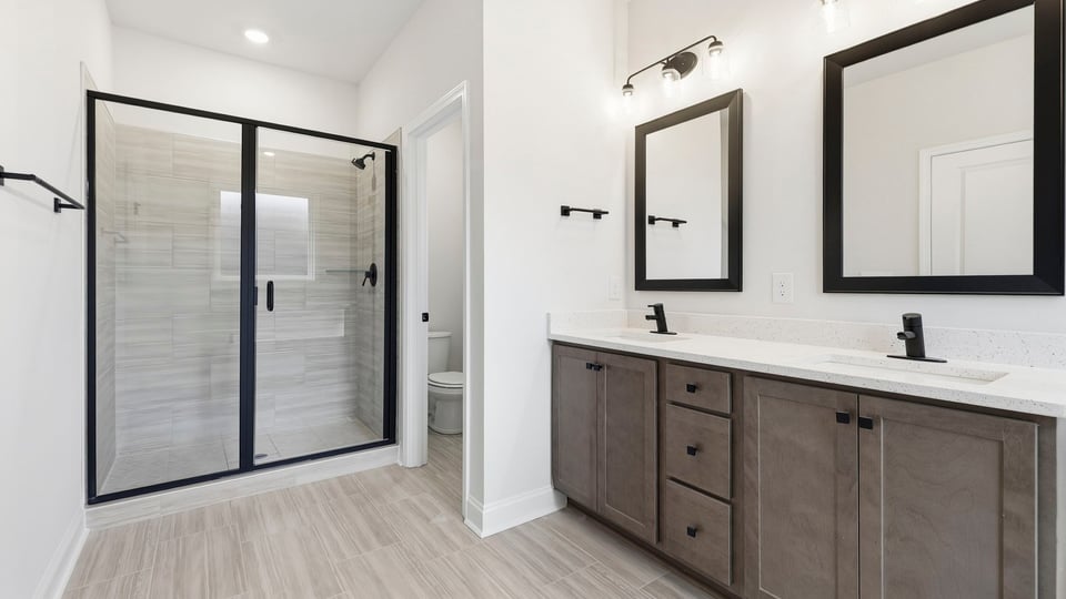Bathroom with double vanity sink and walk in shower.