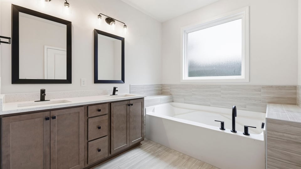 Bathroom with double vanity sink and bathtub.