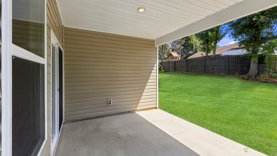 Back exterior of home with covered patio.