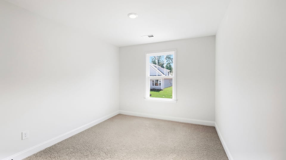 Bedroom with carpet and window.