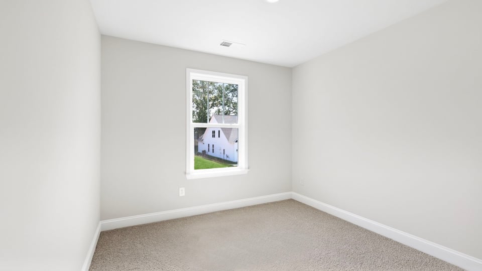 Bedroom with carpet and window.