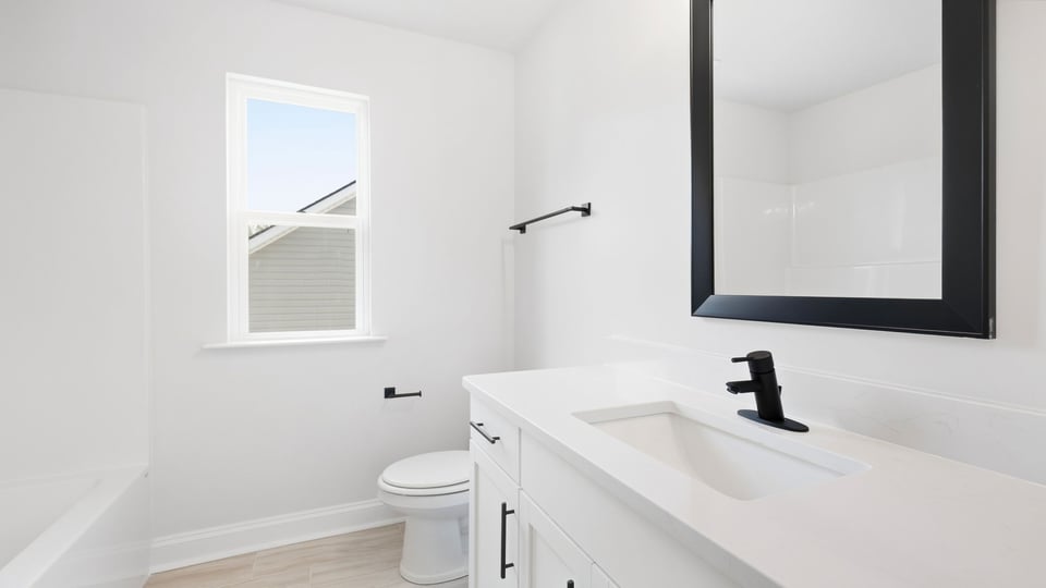 Bathroom with window and single vanity sink.