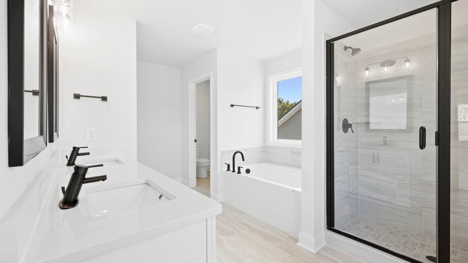 Bathroom with double vanity sink and walk in shower.