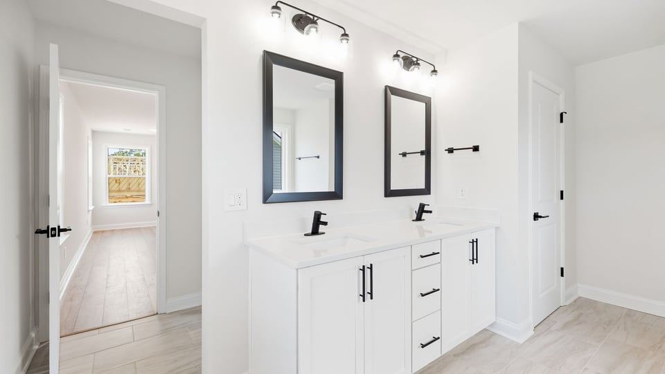 Bathroom with double vanity sink and walk in shower.