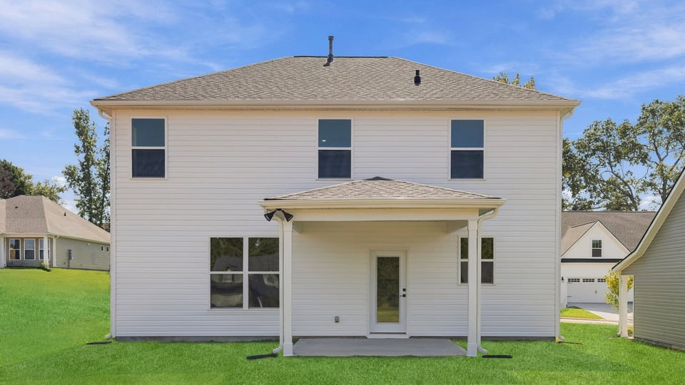 Back exterior of home with large backyard.