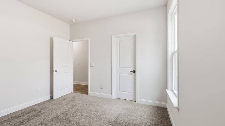 Bedroom with carpet and window.