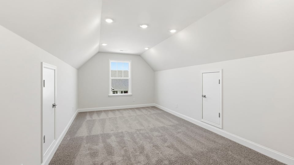 Loft area with carpet and window.