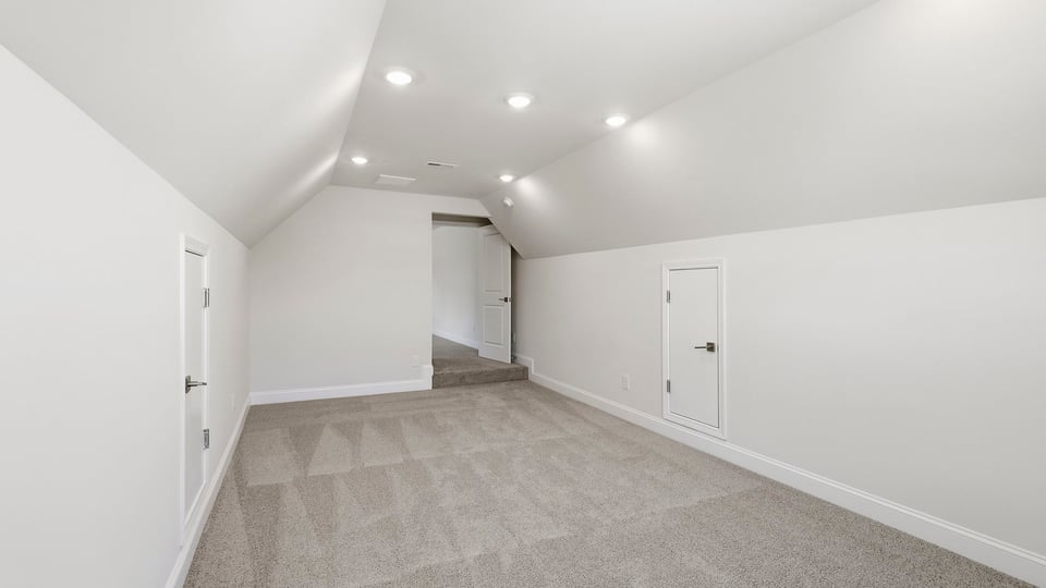 Loft area with carpet and window.