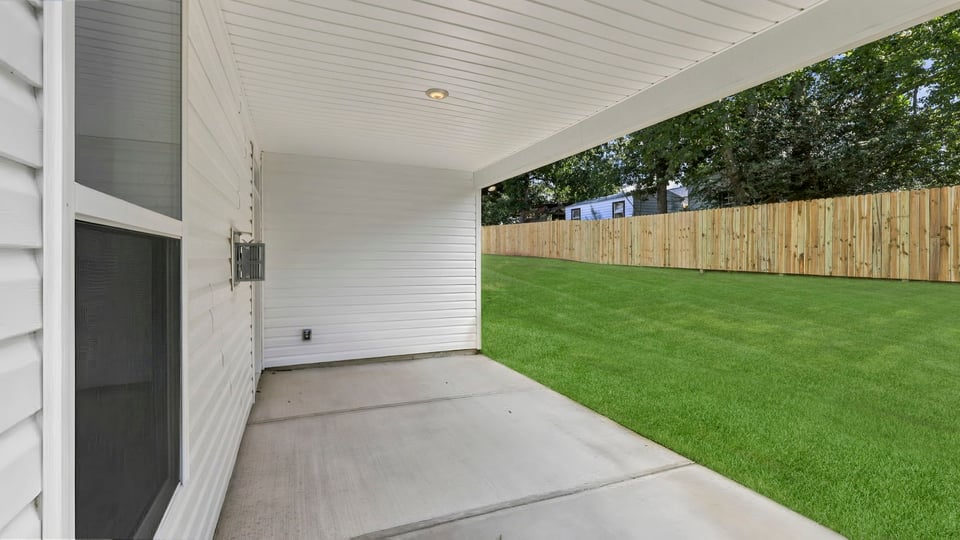 Back exterior of home with covered patio.