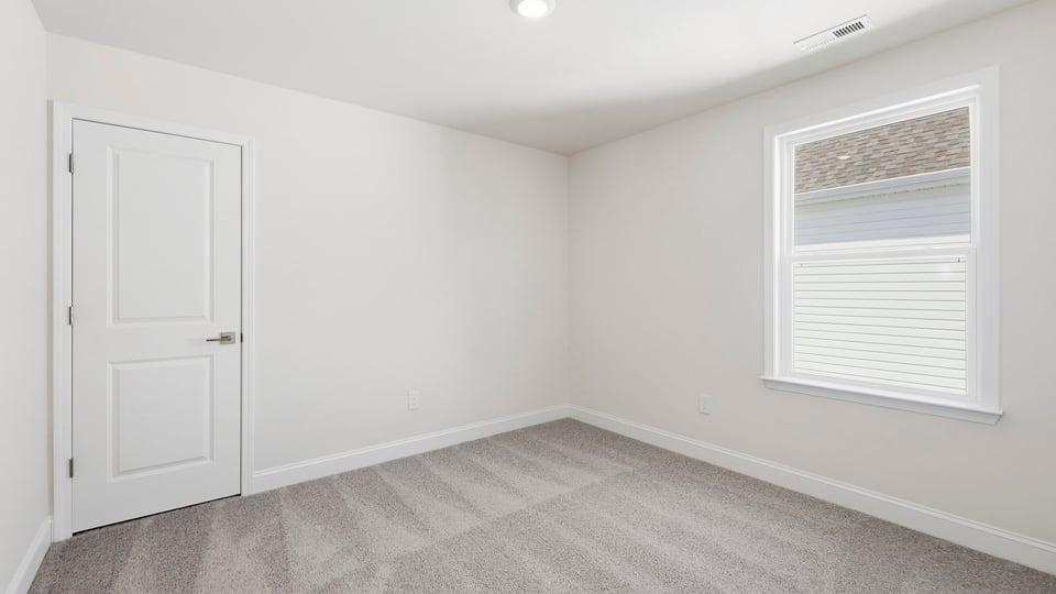 Bedroom with carpet and window.