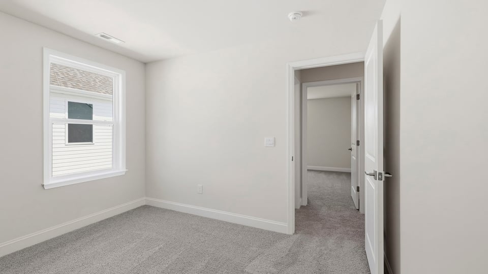 Bedroom with carpet and window.