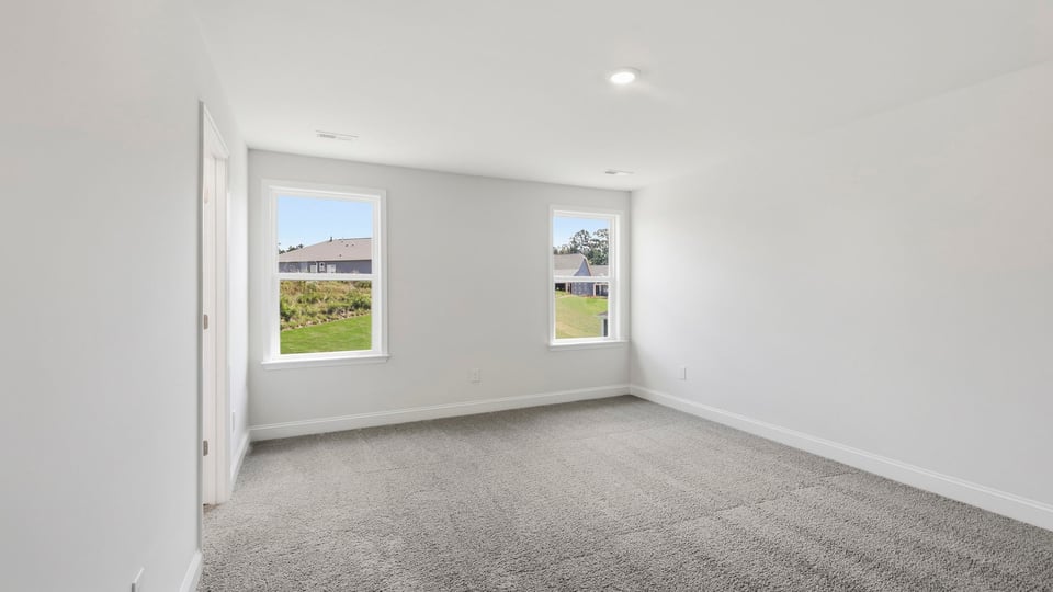 Bedroom with carpet and windows.