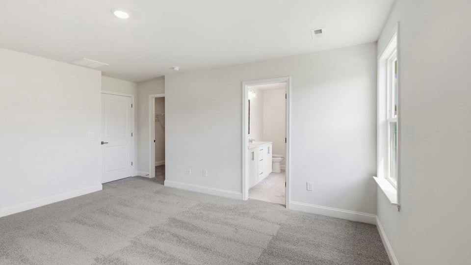 Bedroom with carpet and windows.
