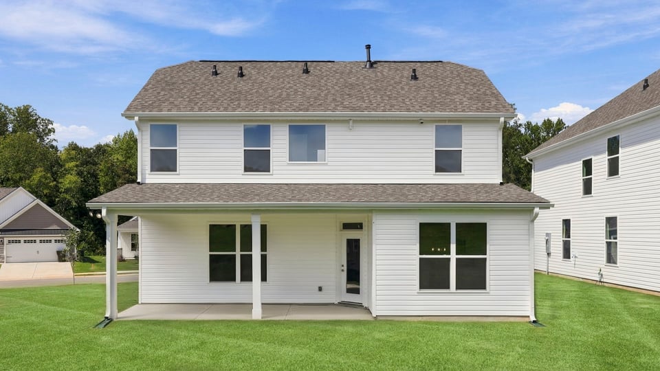 Back exterior of home with large backyard.