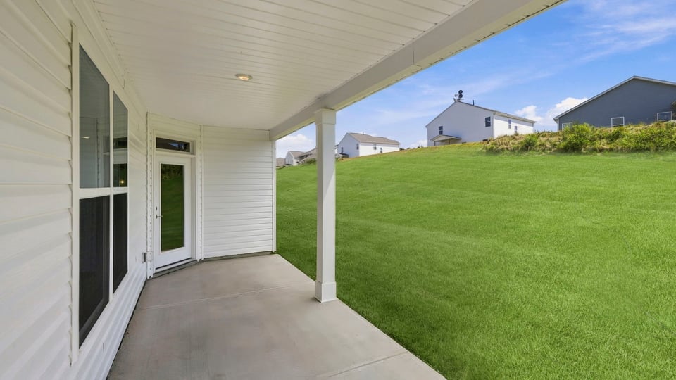 Back exterior of home with covered patio.
