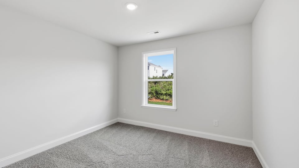 Bedroom with carpet and window.
