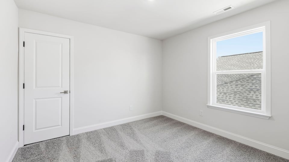 Bedroom with carpet and window.