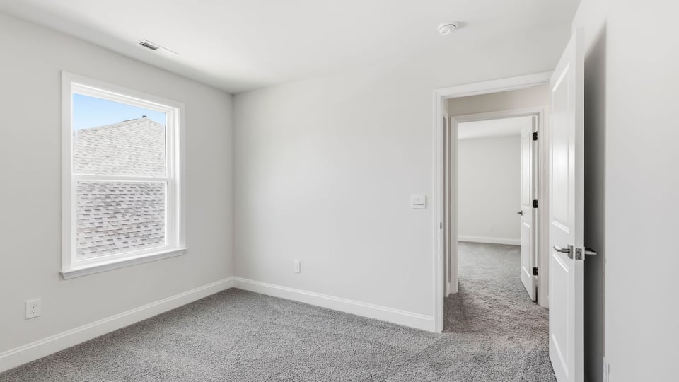 Bedroom with carpet and window.