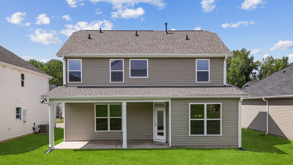 Back exterior of home with large backyard.
