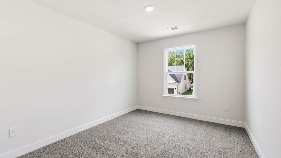 Bedroom with carpet and window.