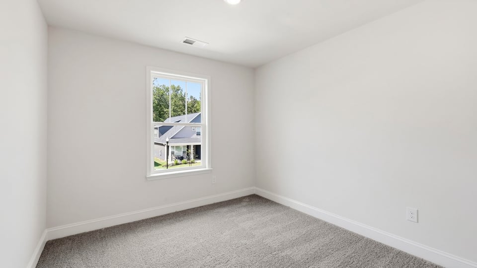 Bedroom with carpet and window.