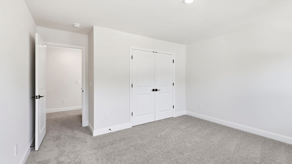 Bedroom with carpet and window.
