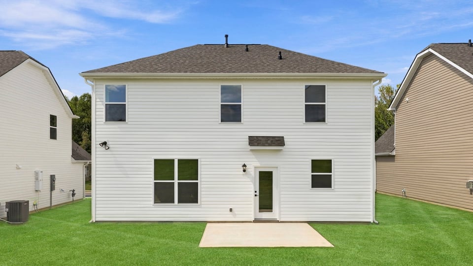 Back exterior of home with large backyard.